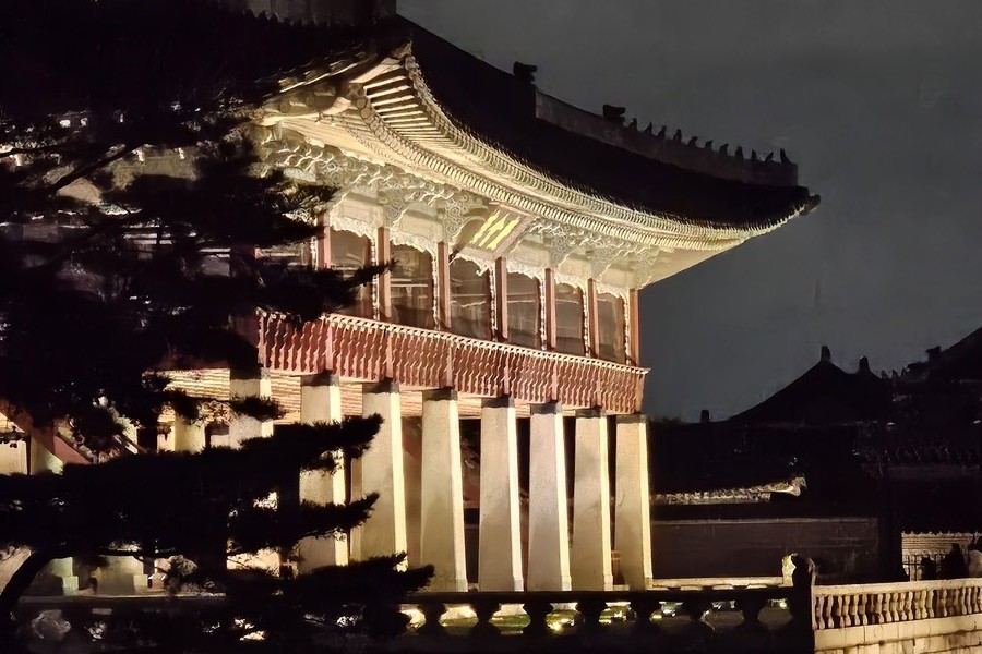 Gyeonghoeru pavilion at Gyeongbokgung lit up at night and reflected in the still pond below