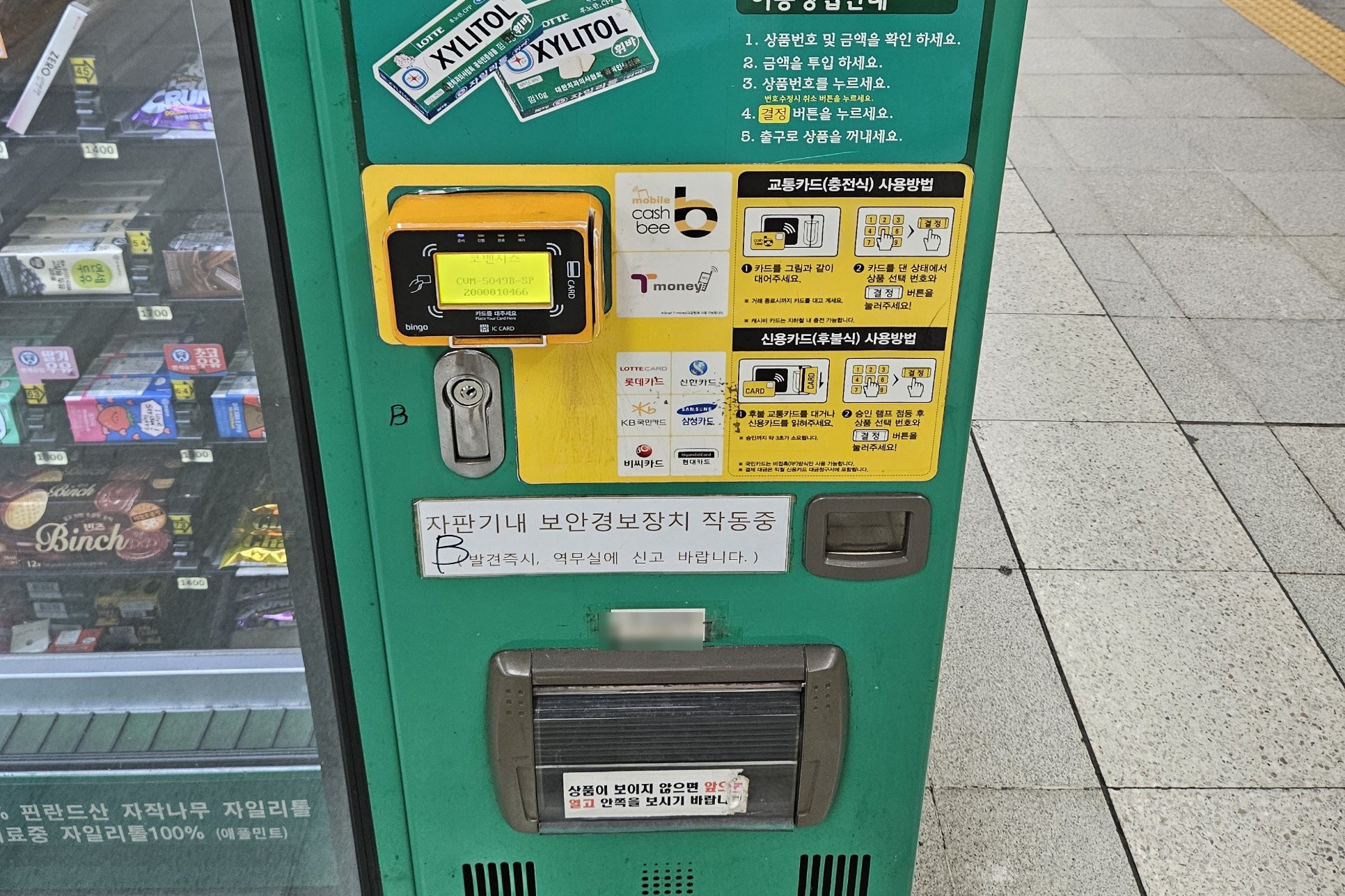 A snack vending machine on a Seoul subway platform with a card reader and a sticker showing T-money and Cashbee logos
