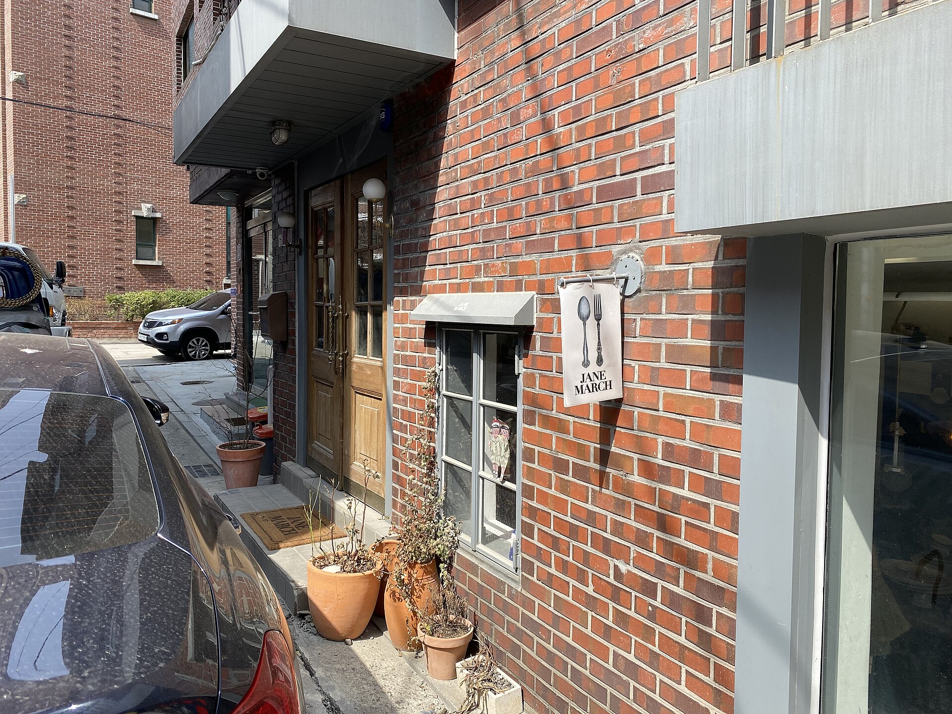Red brick storefront with potted plants on a side street in Seongsu-dong, Seoul