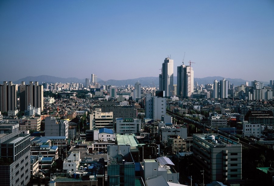 Rooftop view over Seongsu-dong in 2005, low factory and office buildings packed together under high-rise towers in the distance