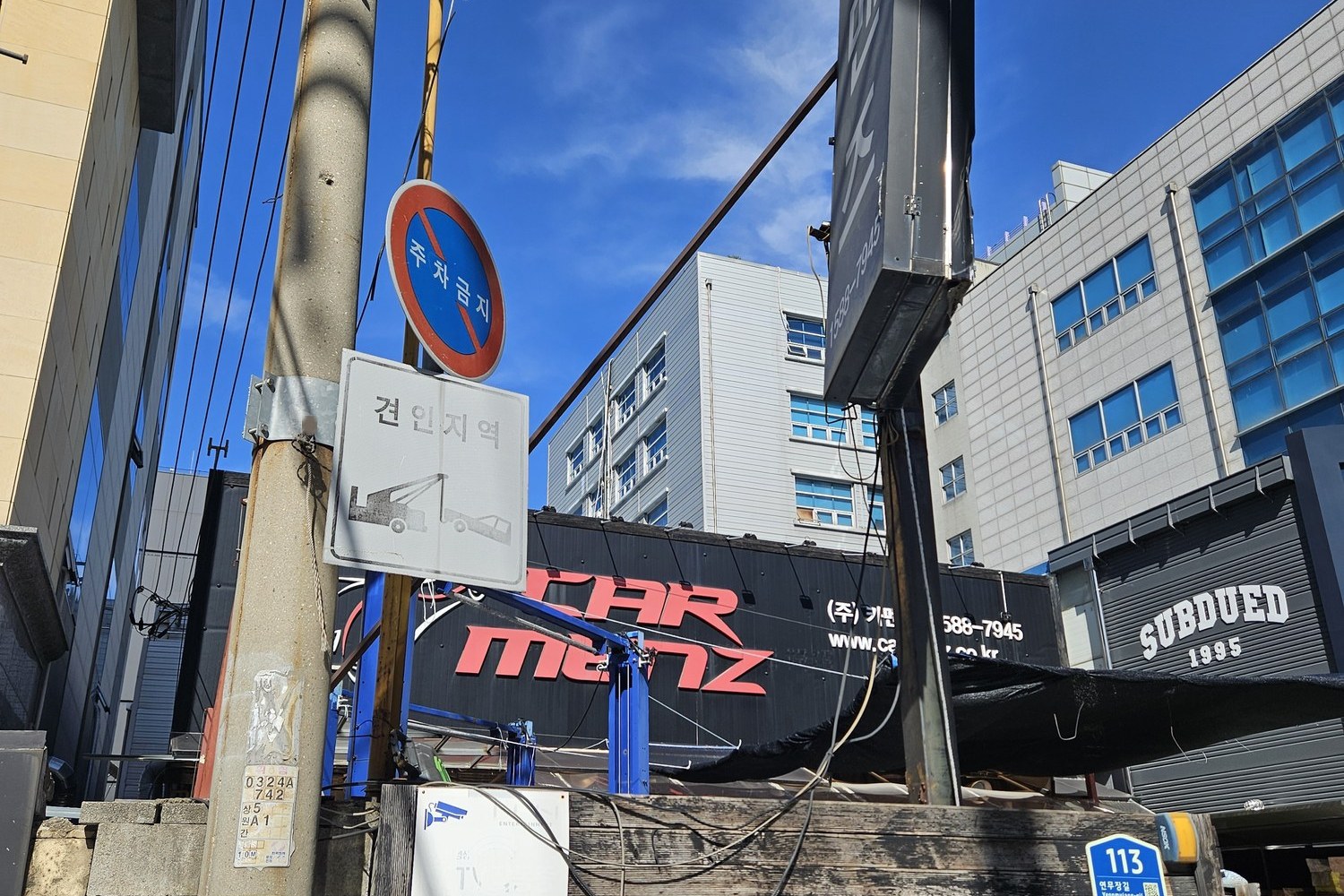 A Car Menz sign and a Subdued fashion store on the same Seongsu corner