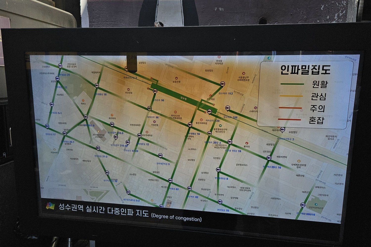 Screen showing a live crowd density map of the Seongsu area with streets marked green, yellow and red