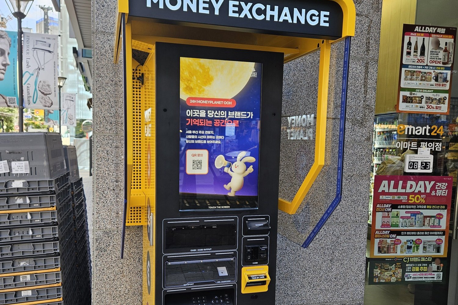 A yellow money exchange kiosk on a Seongsu street next to a convenience store