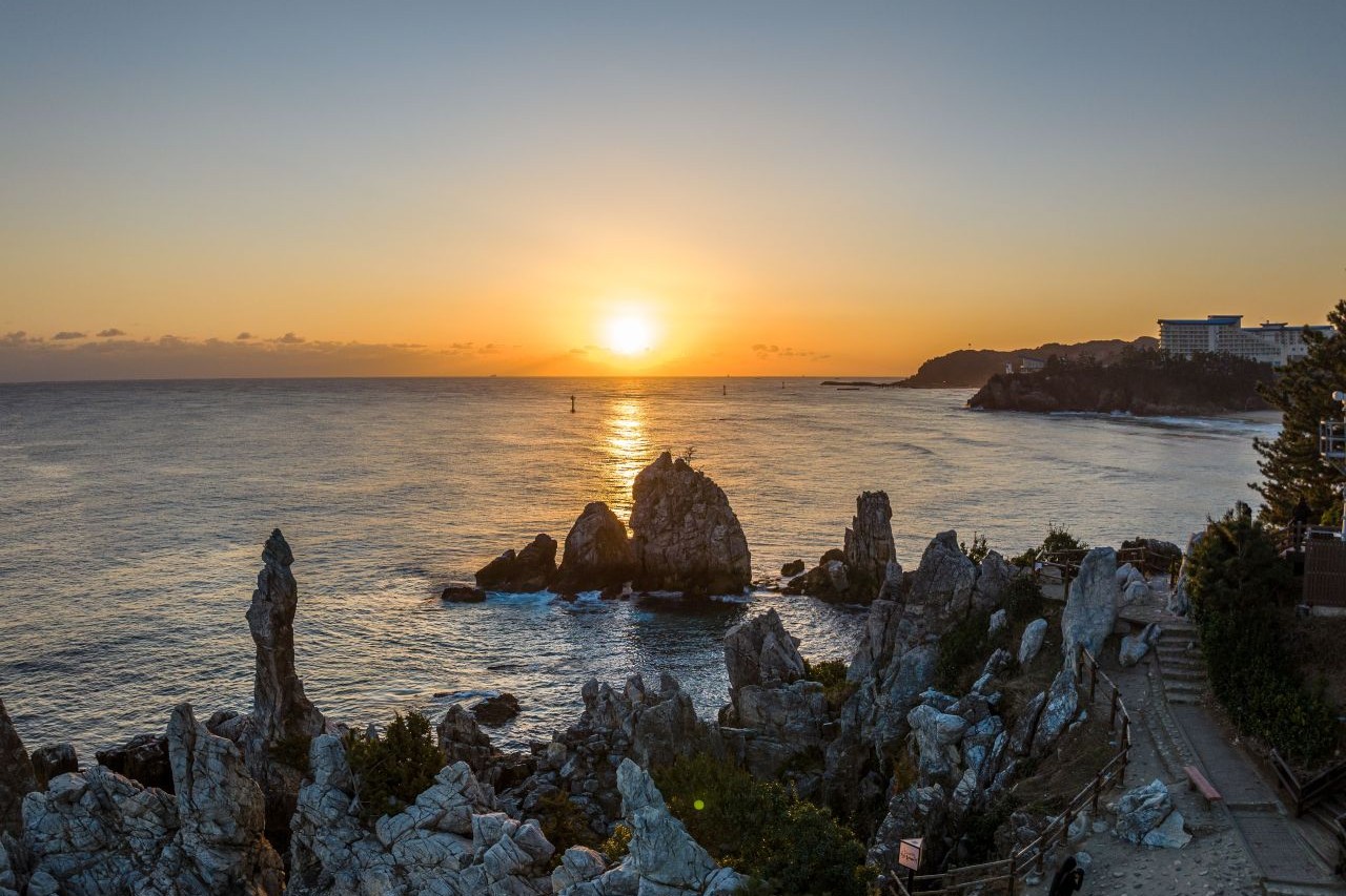 The sun rising over the sea behind the Chuam Candlestick Rock and other rock pillars in Donghae