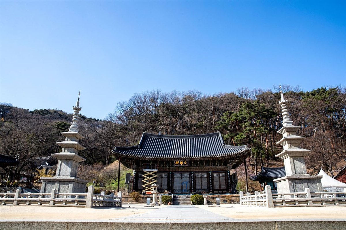 Jikjisa Temple main hall under a blue sky with a stone pagoda beside it