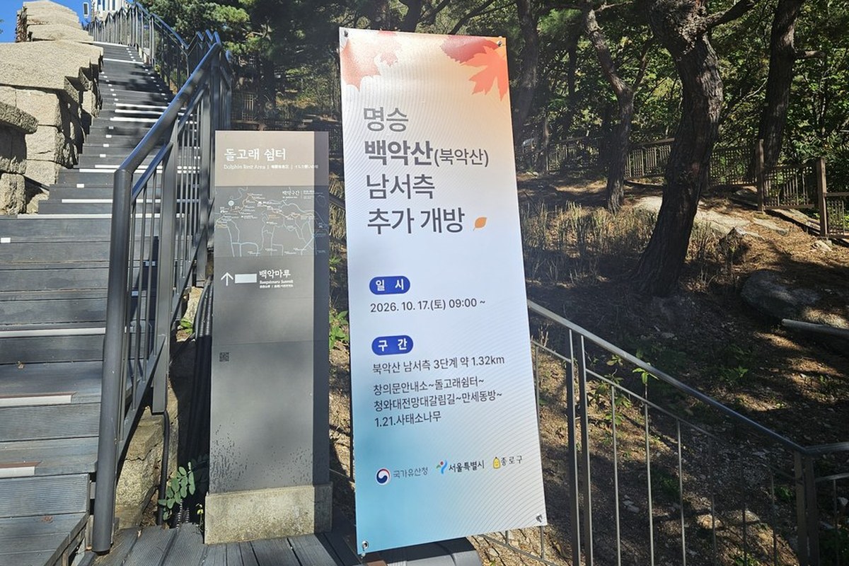 A banner beside a stair path on Bugaksan announcing the additional opening of the southwest side of Bugaksan on Oct 17, 2026