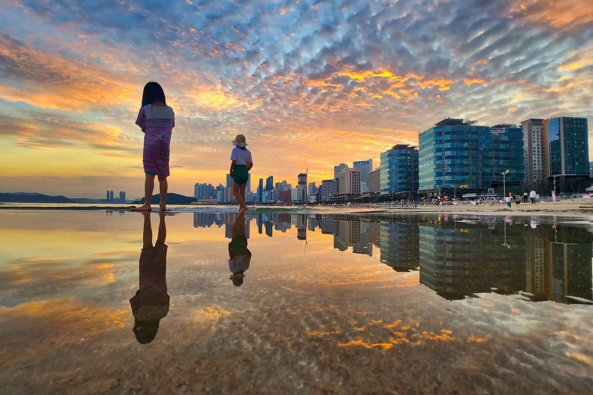 Sunset over Haeundae Beach in Busan with people on the sand