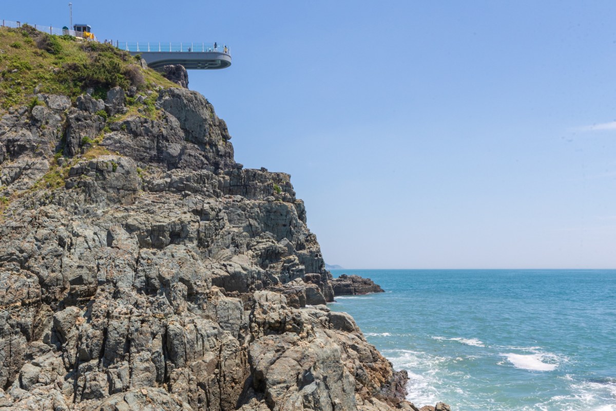 Oryukdo coast in Busan with a rocky headland, the Skywalk platform on top and the sea beyond