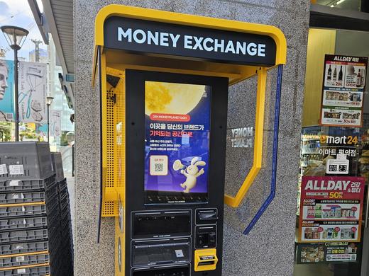 A yellow currency exchange kiosk on a street in Seongsu-dong, Seoul