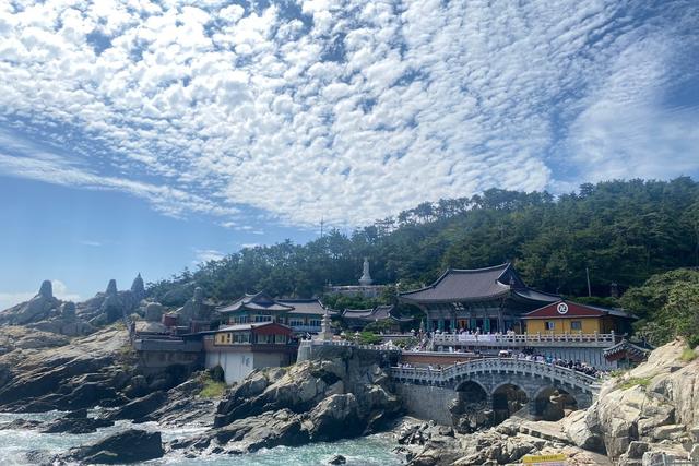 Haedong Yonggungsa, a temple on the rocks above the sea in Busan, under a sky of small clouds