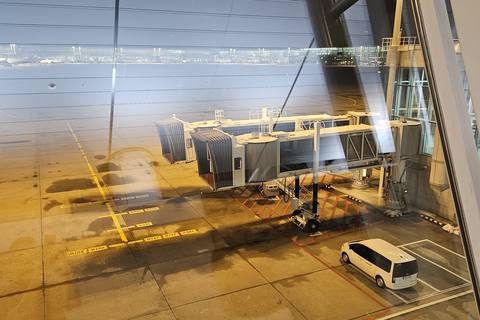 A boarding bridge seen through an airport window at night at Incheon Airport
