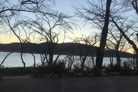 Bare winter trees against a sunset sky beside a lake in Gyeongju